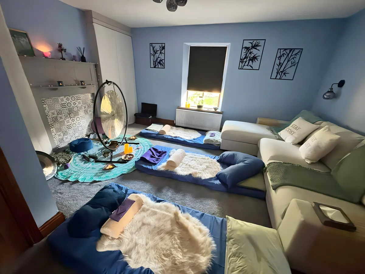 The studio laid out for a session: mats, blankets and cushions.